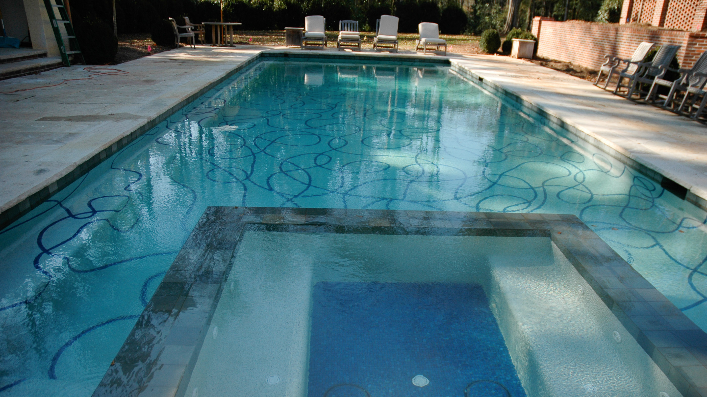 View of swimming pool lined with tile ribbons decorating the pool basin